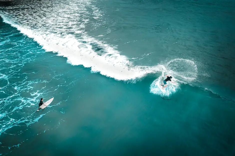 A photograph of a drone capturing an aerial shot of a surfer riding a wave with blue skies in the background.