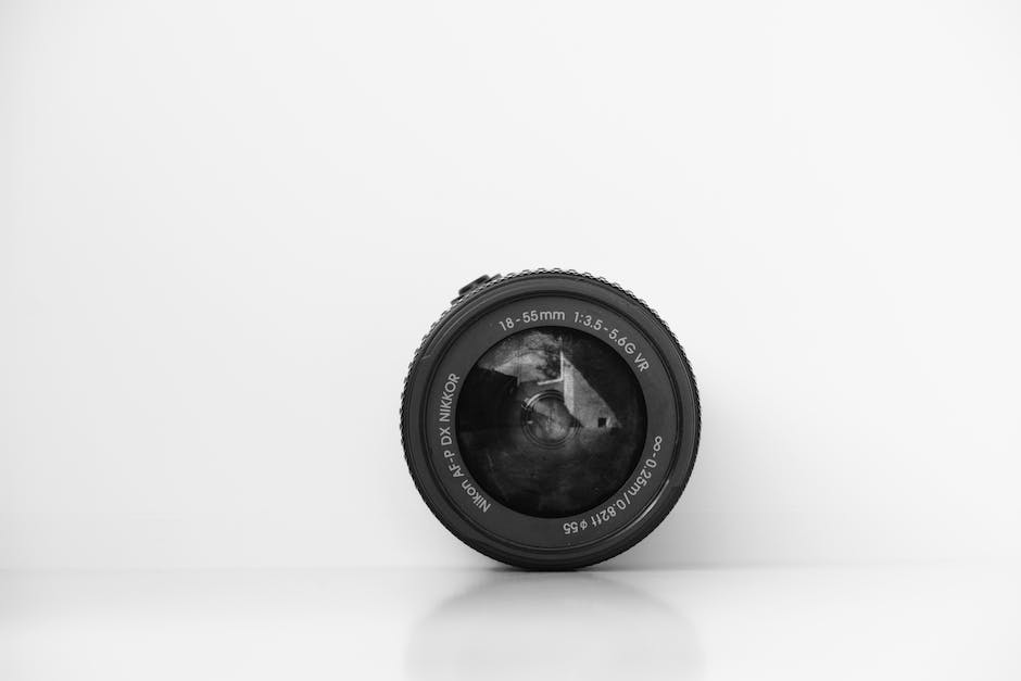 A photograph of a camera lens with the word Depth of Field in focus in front of a blurry background.