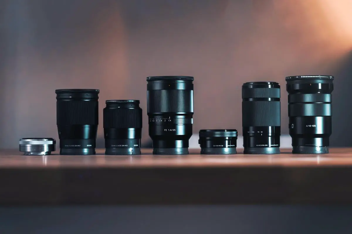 A camera surrounded by different lenses to depict choosing the best lens for travel photography