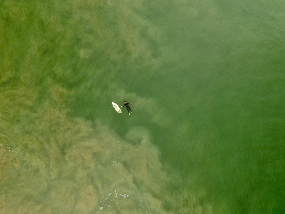 A picture of a drone capturing aerial surf photography with the ocean in the background.