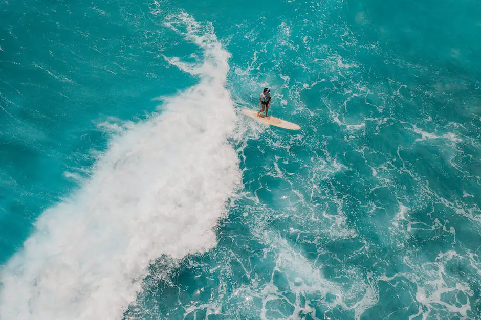 A surfer catching a wave from a birds-eye view with a drone.