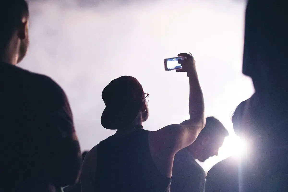 Image of a person recording a concert with an iPhone