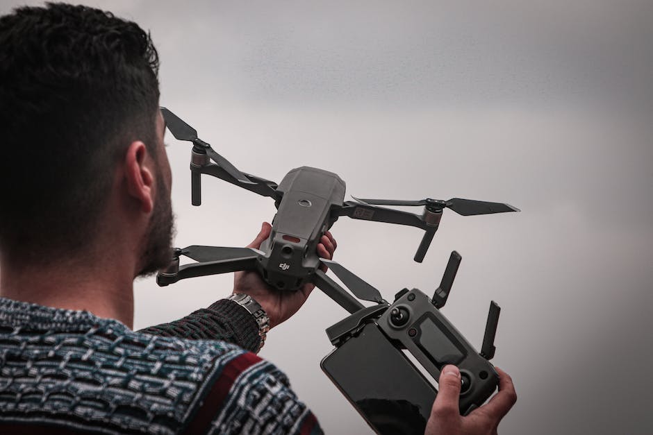 Image of a person using the DJI Fly App with a Mavic Mini drone in the background.