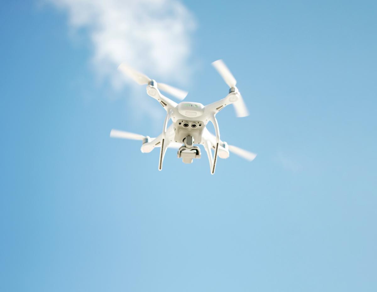 A picture of several drone models flying in the sky with an overlay of text that says 'Drone Insurance: How to Choose the Right Coverage Plan'