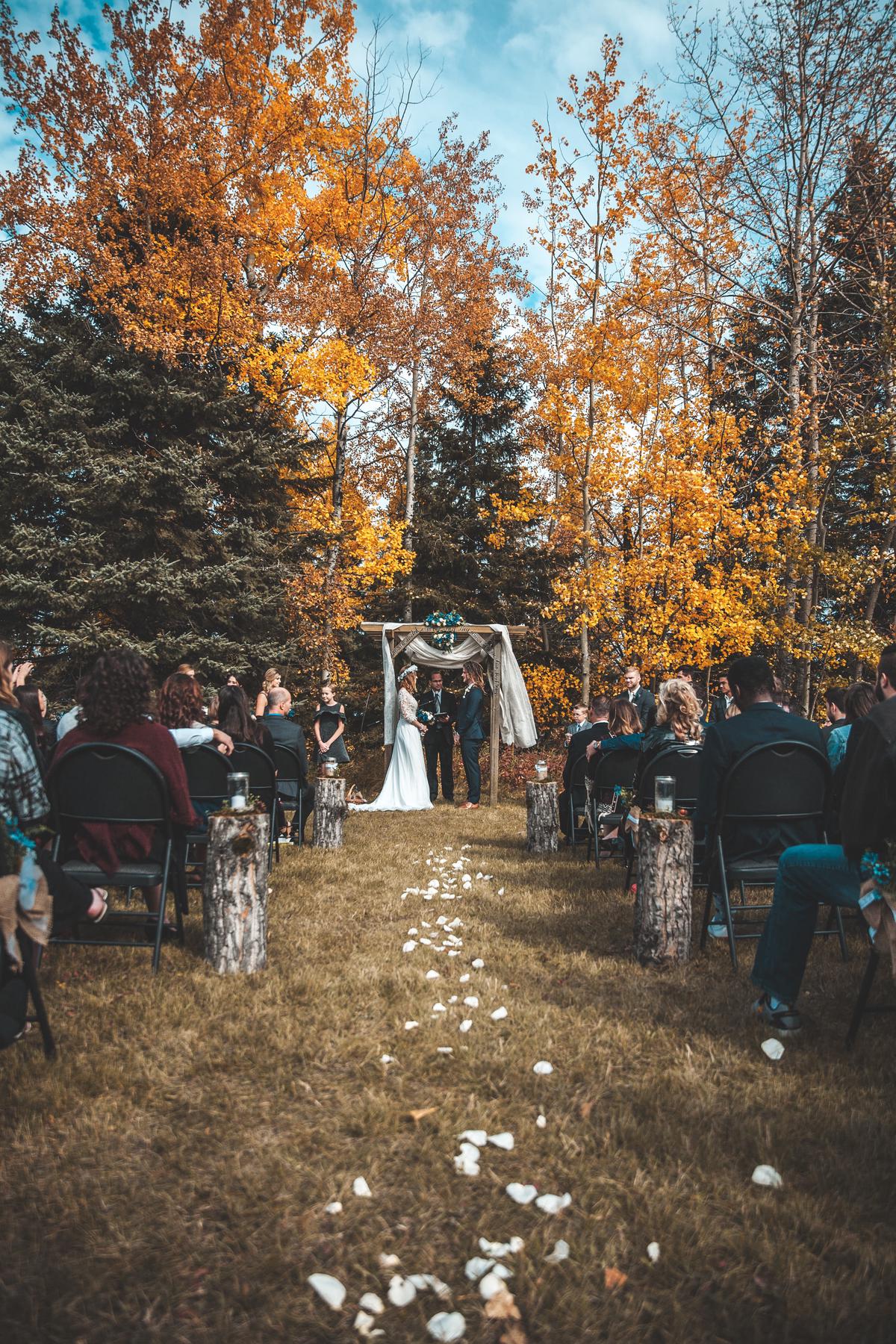 A photographer holding a camera and taking a picture during a wedding ceremony, showcasing the importance of having the right lenses for event photography