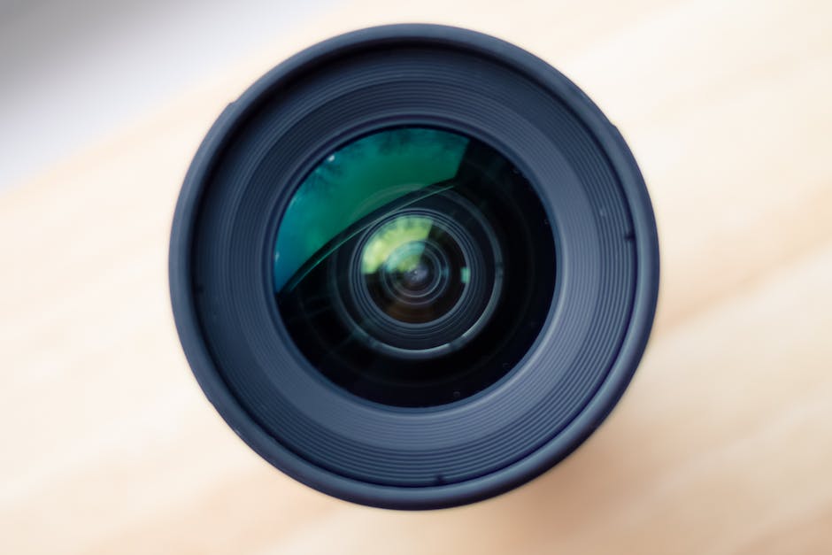 A black medium-telephoto lens with a red line in the middle of the lens for Canon cameras