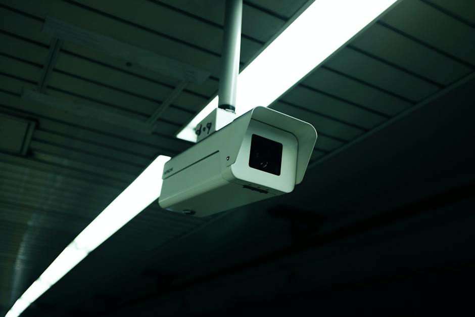 A surveillance camera mounted on a wall, monitoring an area for security purposes.