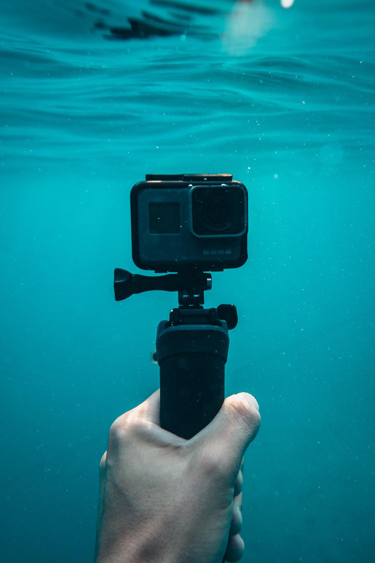 An image depicting various underwater photography equipment such as waterproof cameras, underwater housings, lenses, lighting equipment, and other accessories.
