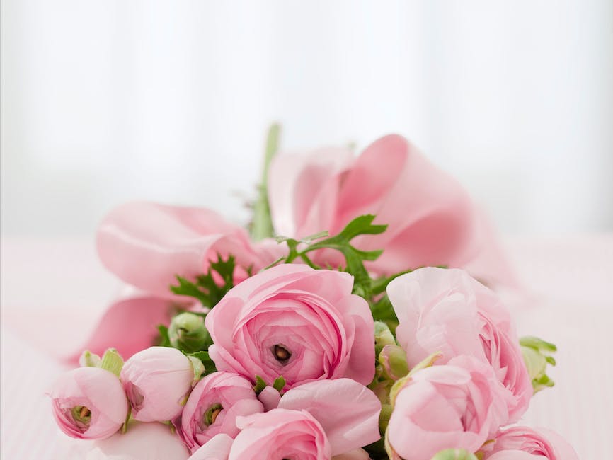 A photo of a camera lens pointed towards a flower arrangement, showing the difference in focus between the foreground and blurred background, suggesting the versatility required in a lens for wedding photography.